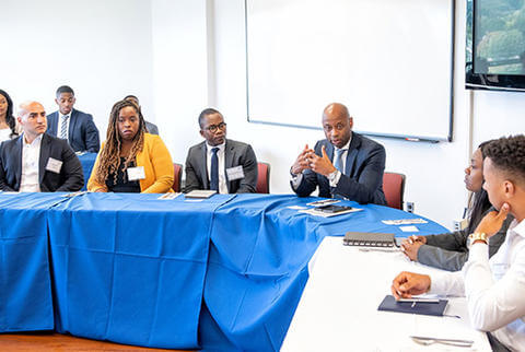 People gathered around a table during a discussion at the Citigroup day event